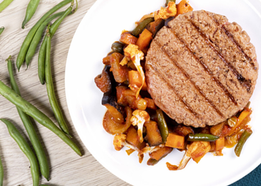 Hamburger di vitello con caponata di fine estate nel piatto