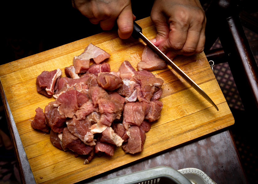 Tagli  di vitello per spezzatino su tagliere di legno