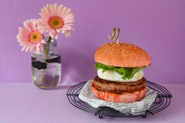 Panino rosa con hamburger, tomino e salsa di pomodori secchi